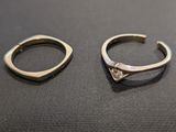 two rings with a diamond on them sitting on a table