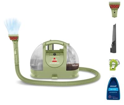 l'aspirateur est vert et est équipé d'un tuyau et d'un vaporisateur