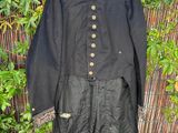 a black jacket hanging on a bamboo fence next to a bush