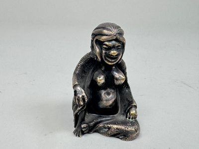 une petite statue représentant un singe assis par terre