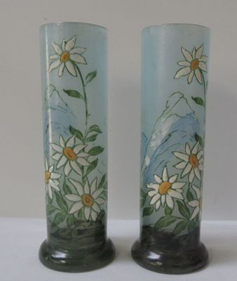 deux vases décorés de fleurs, posés sur une table