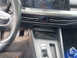 a car dashboard with a steering wheel and a drink can in it