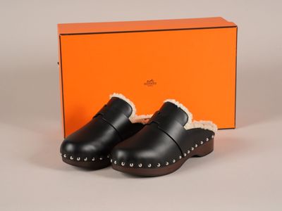 une paire de sabots noirs doublés de fourrure sur tout le pourtour