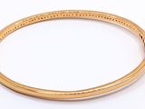 gold plated bang bracelet with black stones on a white background
