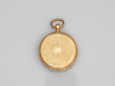 une vieille montre de poche en or avec une chaîne, posée sur une surface blanche