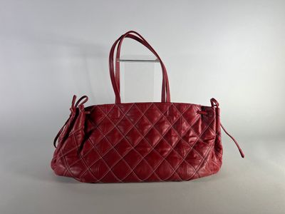 a red leather handbag with a zippered handle on a white background