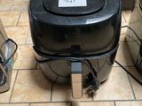 une poubelle noire posée par terre à côté d'autres poubelles