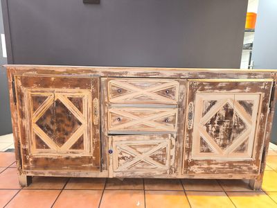 une très vieille armoire en bois posée sur un sol carrelé