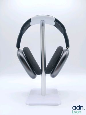 un casque posé sur un support, sur une surface blanche
