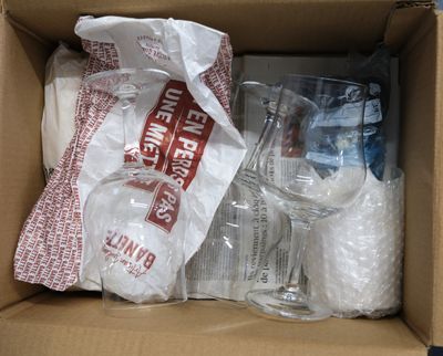 a cardboard box with a bunch of empty wine glasses inside of it