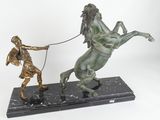 bronze statue of a man on a horse pulling a rope
