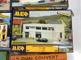 four boxes of miniature model buildings on a table