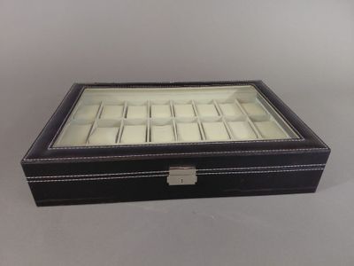 une image représentant un coffret à montre en cuir noir sur fond blanc