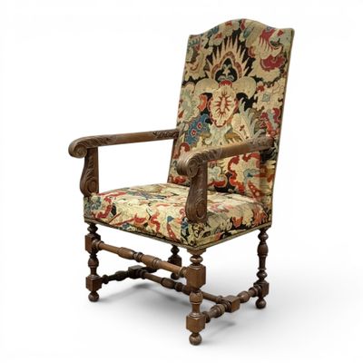 an old chair with a floral upholstered seat and wooden legs