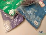 many bags of clothing that are sitting on top of a table