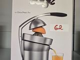 une boîte contenant un presse-agrumes et un verre de jus d'orange
