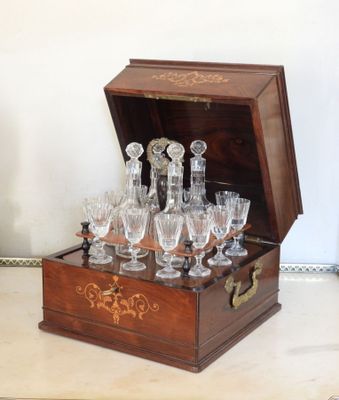 des bouteilles et des verres dans une caisse en bois posée sur une table
