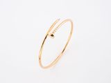 a gold bang with a single black diamond on it