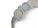 a close up of a brooch with spiral designs on it