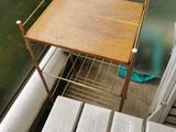 a small table with a shelf on it next to a window