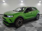 un SUV vert garé dans une pièce au sol carrelé