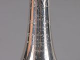 a silver vase that has writing on the side of it