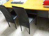 two chairs sitting at a table with a laptop on it