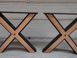 une paire de tables en forme de X, en bois et en métal noir