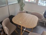 une table et des chaises dans une pièce dotée de grandes fenêtres