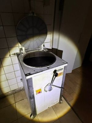 une photo de toilettes dans une salle de bains avec un trou dans le mur