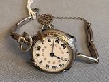 une montre à gousset en argent à laquelle est attachée une chaîne