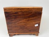 an old wooden box with a label on it sitting on a white surface