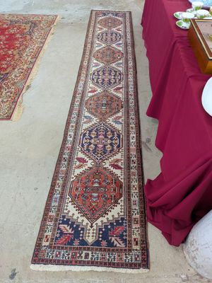 un long tapis posé à même le sol, à côté d'une table sur laquelle sont disposées des assiettes remplies de nourriture