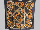 une image représentant un foulard en soie orné de fleurs orange et d'oiseaux