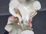 a hand holding a white vase with a flower on it