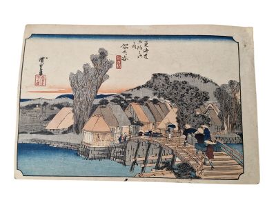 Estampe japonaise représentant un village au bord d'une rivière avec un pont