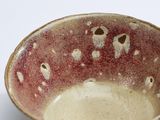 a brown and red bowl sitting on a white surface