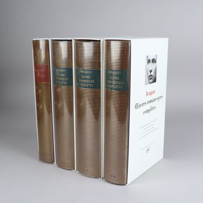four books in a row on a white surface with a gray background