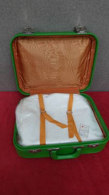 a green suitcase with a white shirt inside of it