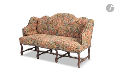un canapé dont le dossier et les accoudoirs sont recouverts d'un tissu à motifs floraux