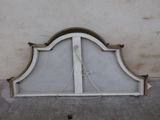 a white bed with a white headboard on the sidewalk