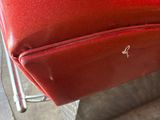 a red suitcase that is sitting on a metal stand