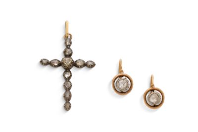 un gros plan d'une croix et d'une paire de boucles d'oreilles sur une surface blanche