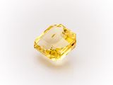 a yellow sapphire stone on a white background