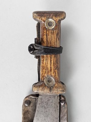 un couteau avec un manche en bois sur une surface blanche