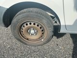 un camion blanc avec un pneu crevé sur la route
