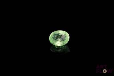 un gros plan d'un cristal vert sur une surface noire