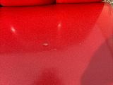 someone is sitting in a red chair with their shadow on the floor