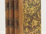 two old books sitting on top of each other on a white surface