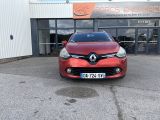 the front of a red car parked in front of a building